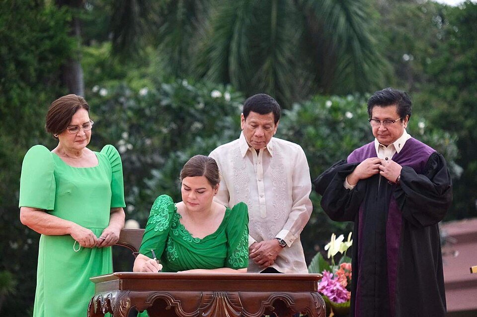 Vice president-elect Sara Duterte, accompanied by her family, signs documents during her inauguration at San Pedro Square, Davao City. (City Government of Davao via Wikimedia)