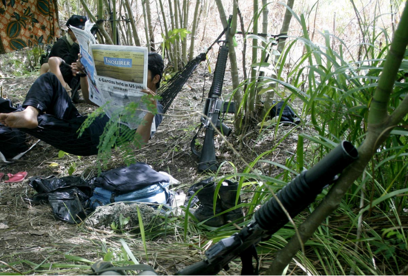 New People’s Army guerrillas under Leoncio Pitao, alias Kumander Parago, read newspapers at their base in Paquibato district, Davao City. (AKP Images/Keith Bacongco via Wikimedia)