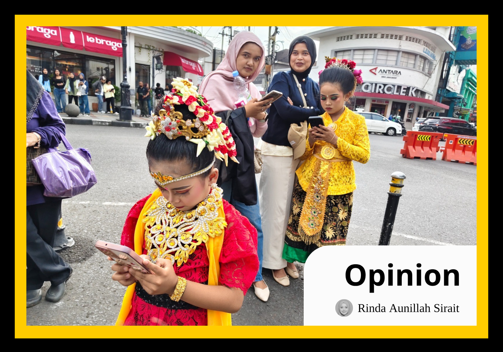 Two young performers in traditional attire remain absorbed in their smartphones amidst the bustle of an historical road in Indonesia. As Indonesia shifts toward “homeless media” and influencer partnerships to broadcast state narratives, this scene captures the tension between preserving cultural substance and chasing the hollow validation of digital reach. (Yogi Ardhi)