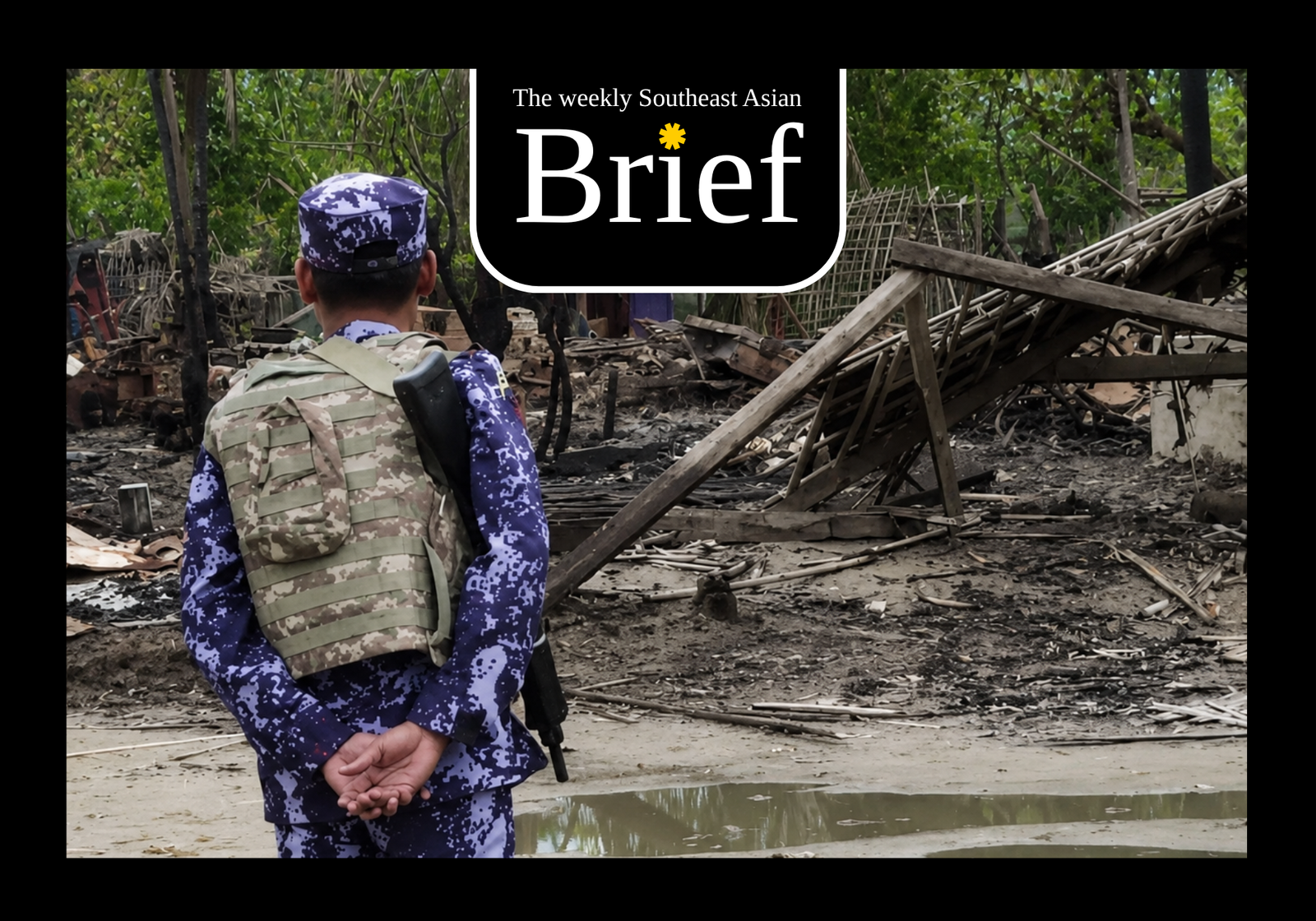 A member of Myanmar's Border Guard Police inspects a house burnt down in an arson attack. (Wikimedia/Steve Stanford)
